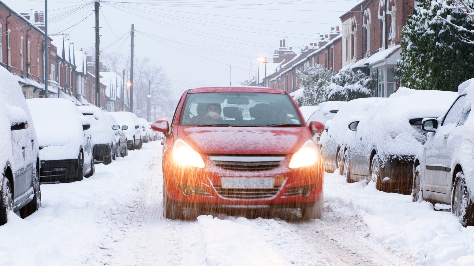 Car driving on snowy residential street